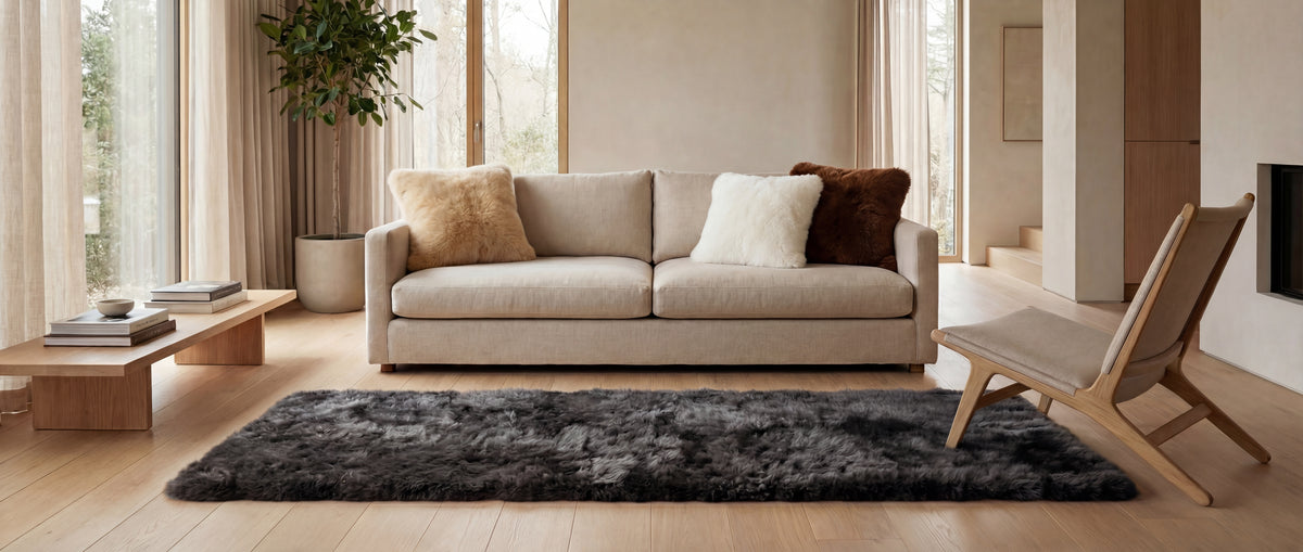 Neutral living room with ivory and chestnut baby alpaca fur cushions and a charcoal alpaca fur rug