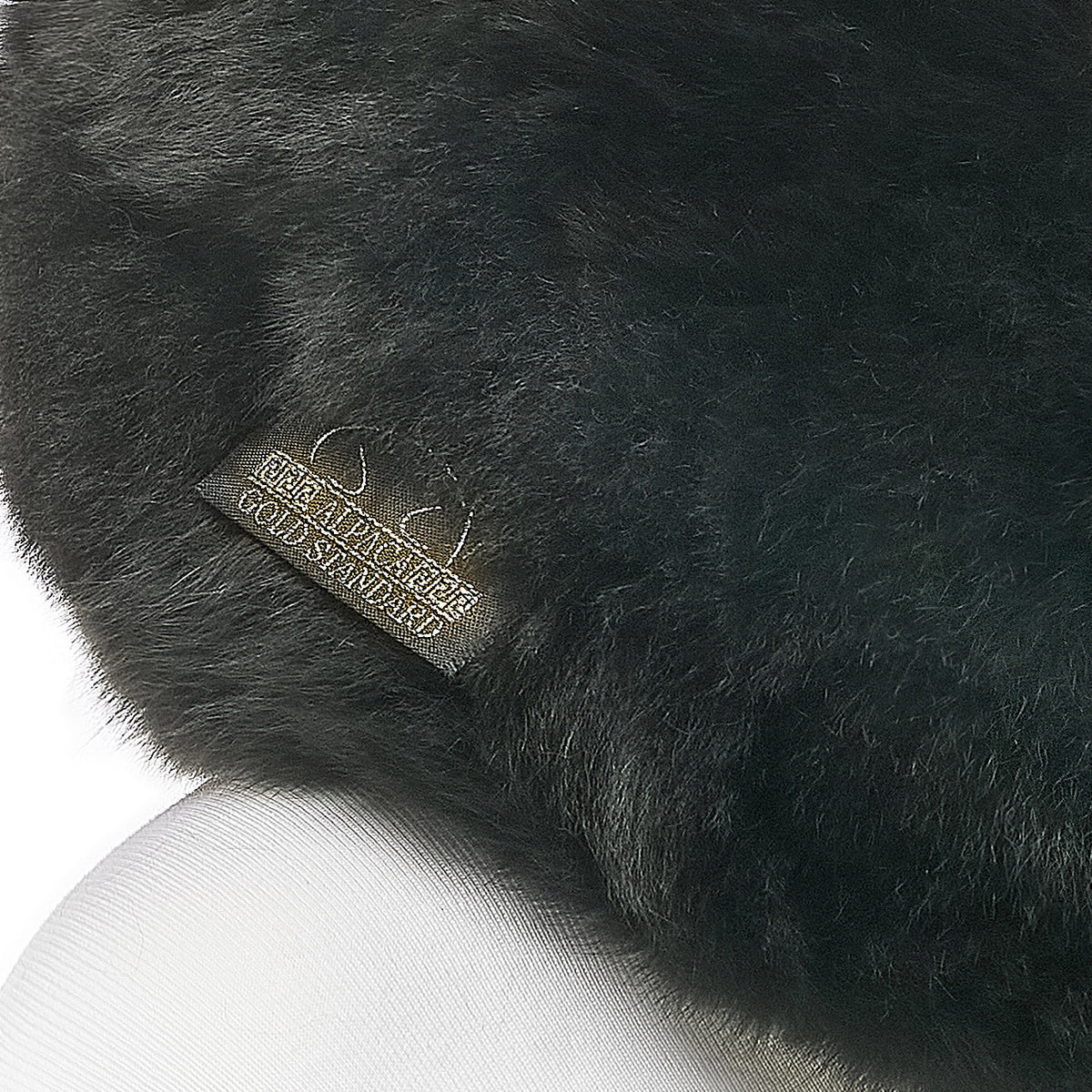 Black baby alpaca fur neck pillow with Alpaca Gold Standard label