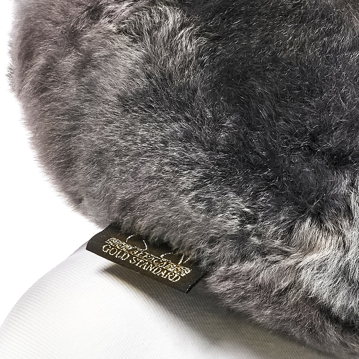 Dark gray baby alpaca fur neck pillow with Alpaca Gold Standard label