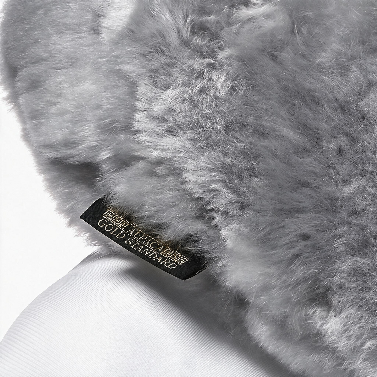 Light gray baby alpaca fur neck pillow with Alpaca Gold Standard label