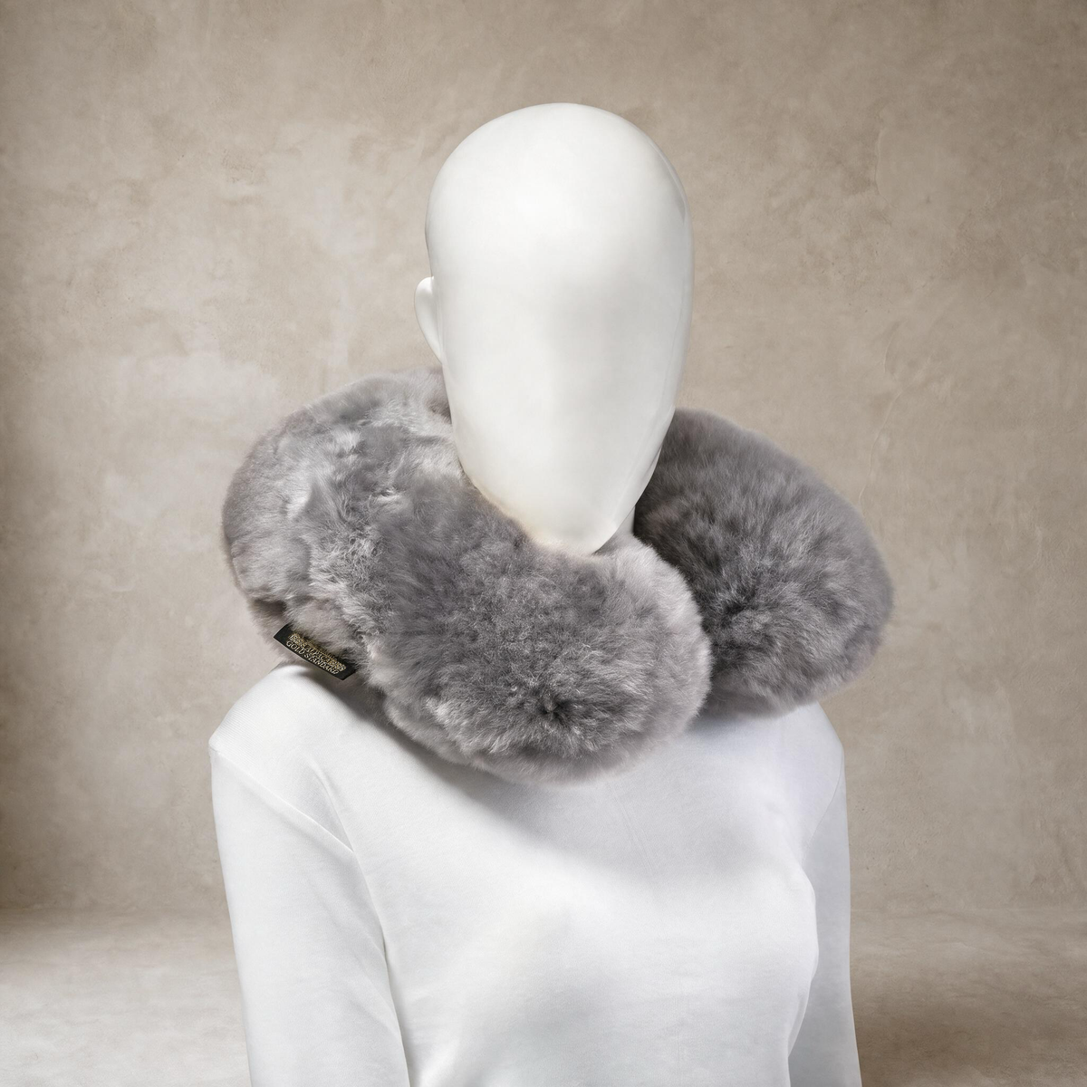 Soft light gray baby alpaca fur neck pillow worn around the neck