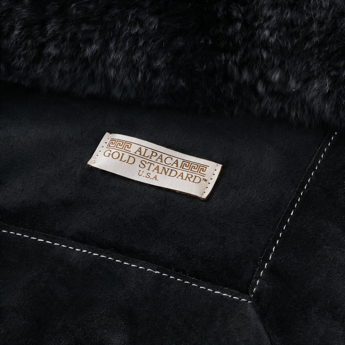 Back of black baby alpaca fur rug with Alpaca Gold Standard label