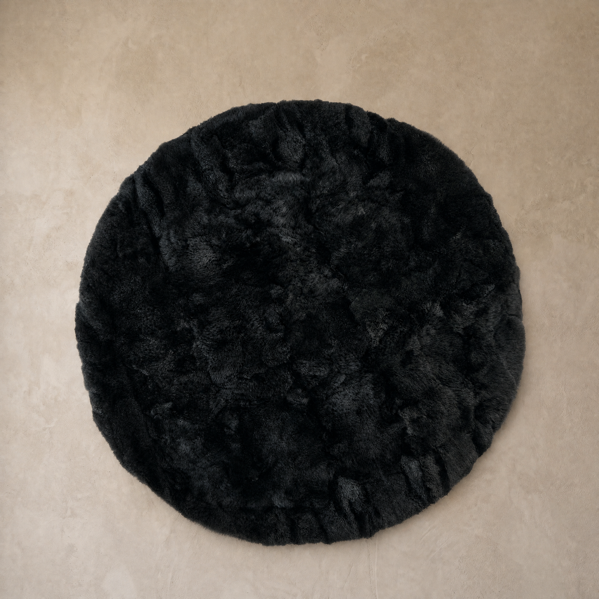 Black round baby alpaca fur area rug